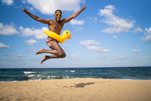Brazilian young man jumping on an empty beach
