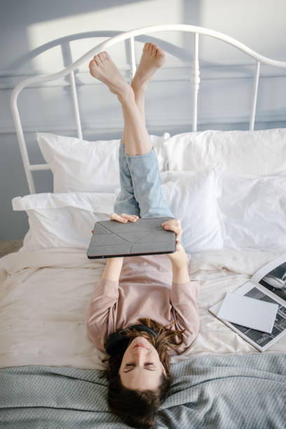 istock woman lying on bed with tablet 1318336994