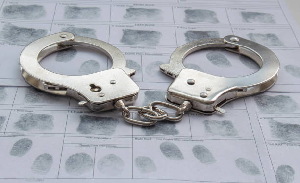 istock Top view of metal Handcuffs with generic hand prints. 1318338318