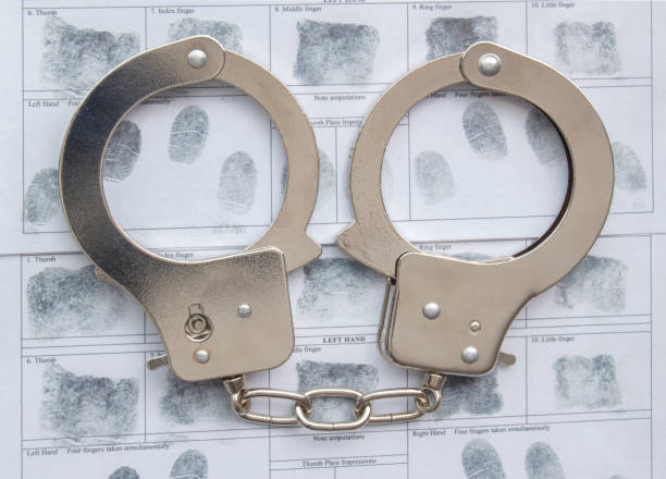 istock Top view of metal Handcuffs with generic hand prints. 1318338319