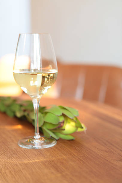 Glass of white wine at the restaurant wooden table. Horizontal image- sunlights at the restaurant interiors, nobody. bar counter blurred background