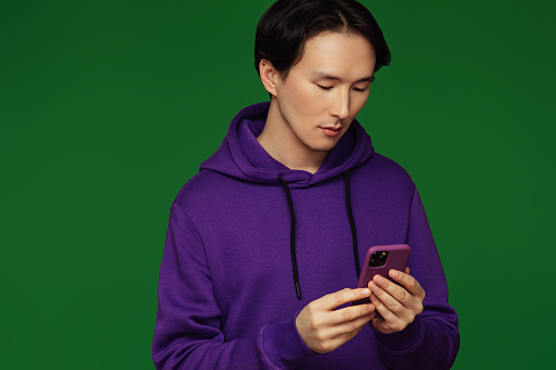 Emotional asian man wearing hoodie with smart phone