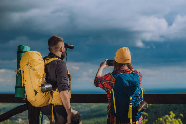 istock Hikers taking photo with a smartphone and looking into nature with a binoculars 1318349416