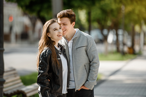 Portrait of a young happy beautiful couple laughing and hugging in the street.