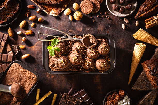 Chocolate ice cream scoop ball, waffle cone, chocolates and mint leaf and toppings Chocolate ice cream scoop ball, waffle cone, chocolates and mint leaf, toppings and ingredients chocolate cake photos stock pictures, royalty-free photos & images