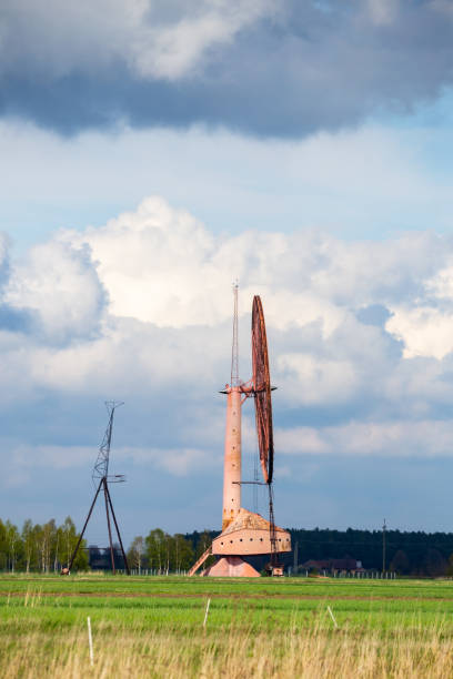 istock An old, closed wind farm standing alone in a field. Object against the sky with tiny clouds. 1318353135