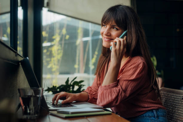 istock Women in Business: Attractive Smiling Businesswoman Talking on the Phone while Working from Home 1318354091