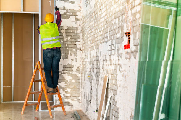 istock maintenance worker with yellow helmet repairing the wall 1318355066