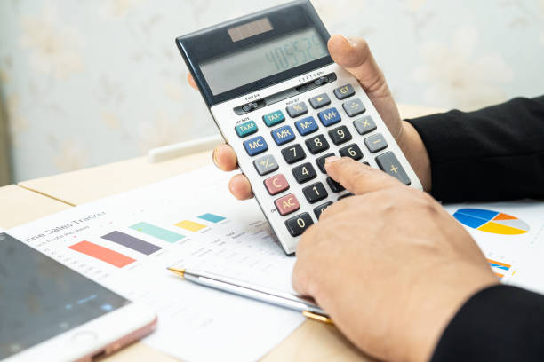istock Asian accountant working and analyzing financial reports project accounting with chart graph and calculator in modern office, finance and business concept. 1318363770