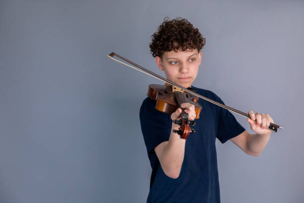 istock Teenage boy playing violin 1318372432
