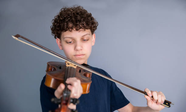 istock Teenage boy playing violin 1318372578