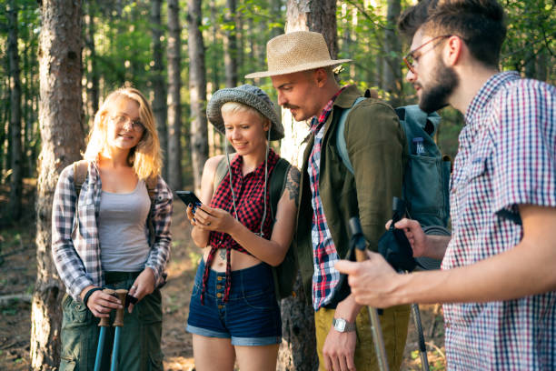 istock Young cheerful friends examining map on the smart phone 1318372597