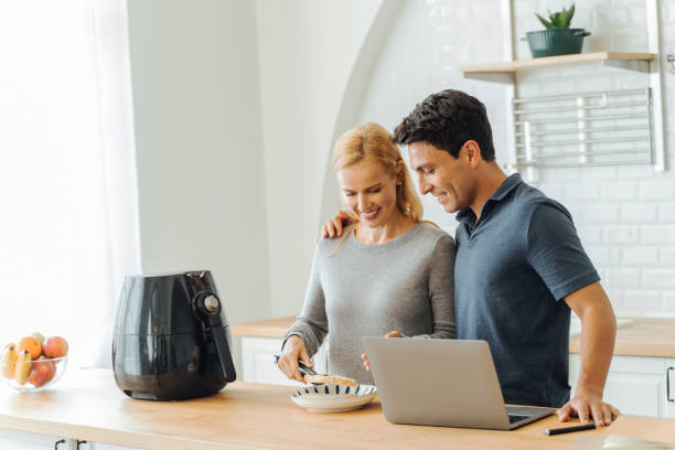 istock Woman working with air fryer and man using laptop 1318372817