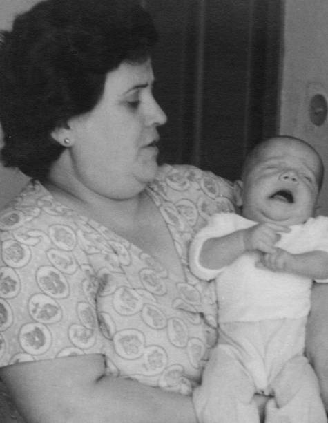 Vintage photo from the 50s, mature overweight woman holding her newborn baby Vintage photo from the 50s, mature overweight woman holding her newborn baby immigrant photos stock pictures, royalty-free photos & images