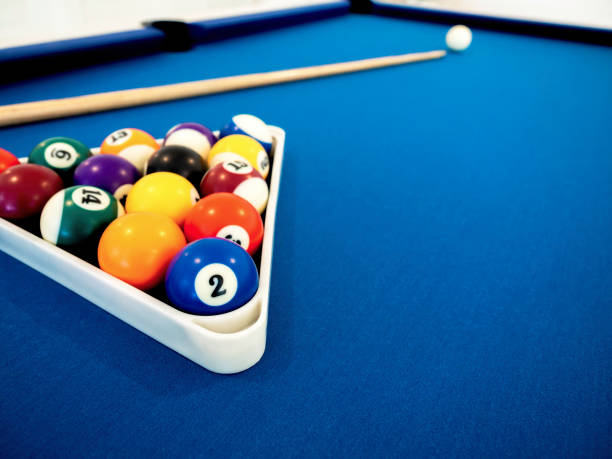 istock Billiard balls in the white triangle and cue on the blue table. 1318379885