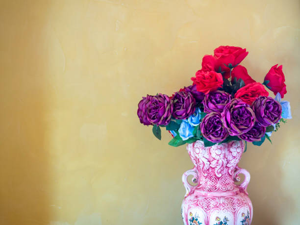 purple roses in a blurred glass vase
