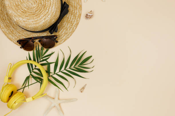 istock Tropical palm leaves, straw hat, starfish, seashells on beige background. Trendy tropical pattern. Fashion clothing and accessories. Flat lay, close up. Summer, vacation, holidays concept. 1318384054
