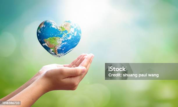World Environment Day Concept Man Opens Palms And Drags Heart Shaped Earth Globe Over Blurred Blue Sky And Water Background Elements Of This Image Furnished By Nasa Stock Photo - Download Image Now