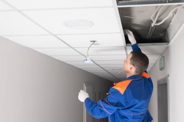 istock a worker is installing a lighting fixture in the ceiling, side view 1318389368