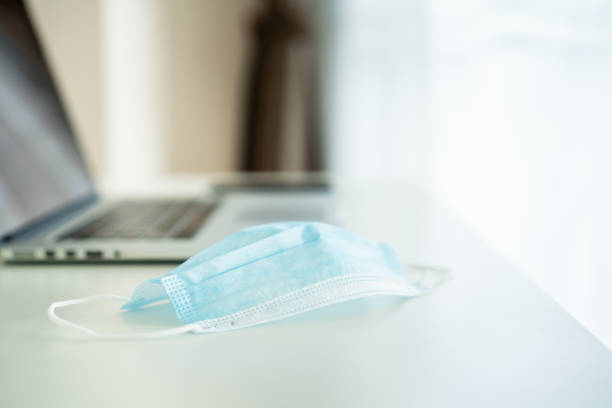 istock Protective hygiene facemask and alcohol gel hand sanitizer on the working table in office. 1318391571