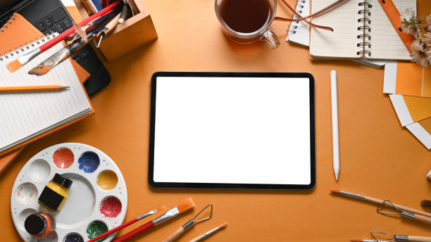 istock Mock up digital tablet, paint brushes, palette, watercolor and notebook on artist workspace. 1318394749
