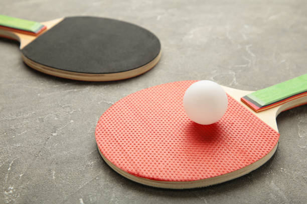 istock Ping pong rackets and balls on grey background. 1318398011