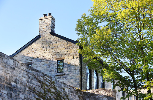 Historic site building in downtown Kingston, Ontario with spring foliage.