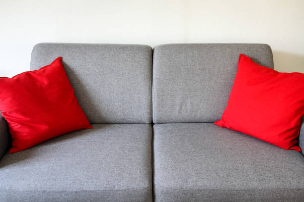istock Grey sofa close-up view with red cushions 1318401738