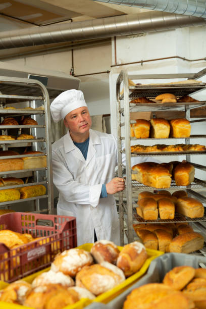 istock Bakery worker pushing trolley with baked loaves 1318402177