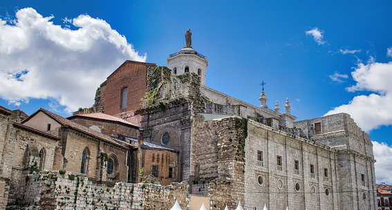 View west façade cathedral of Valladolid, with statue of the sacred heart of Jesus at the top of the bell tower and collegiate ruins in the foreground