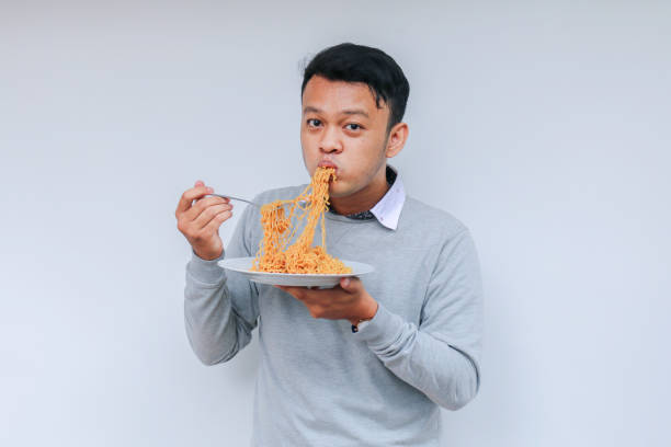istock Young Asian man enjoy noodles. Eating lunch concept. 1318404228