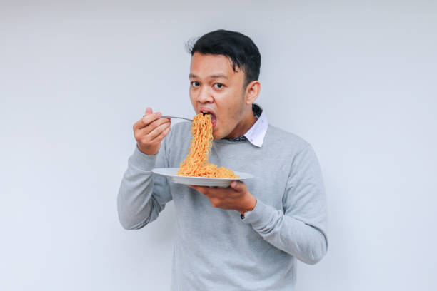 istock Young Asian man enjoy noodles. Eating lunch concept. 1318404342