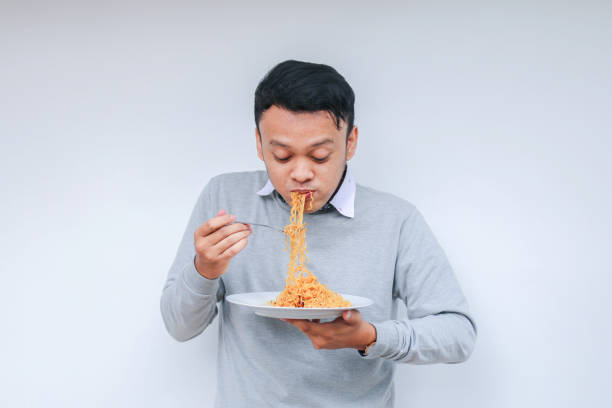 istock Young Asian man enjoy noodles. Eating lunch concept. 1318404362