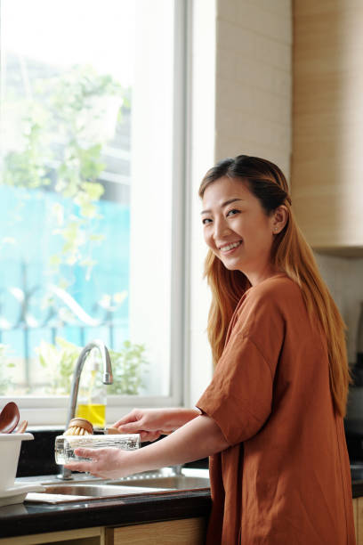 istock Smiling woman washing dishes 1318405467