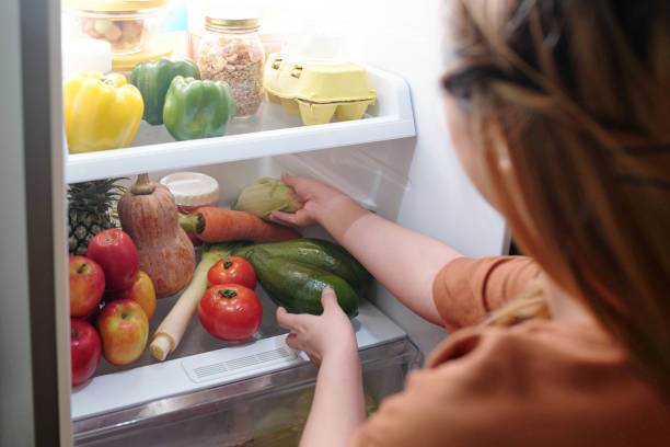 istock Woman reaching for vegetables in refrigerator 1318405531