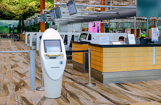 Singapore Jun2020 Changi Airport Terminal 3. An automated self check-in kiosk next to the closed check-in counters. No travellers; deserted empty hall during Covid-19 coronavirus outbreak.