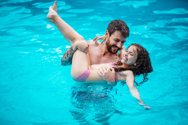 istock Father and daughter having fun in the pool. 1318407232