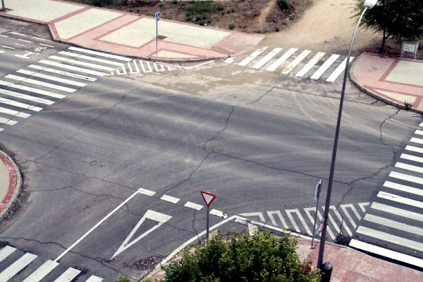 Asphalt street junction seen from above in Madrid, Spain. Traffic signs drawn on the asphalt indicating the preferences of passage. crossing sign stock pictures, royalty-free photos & images