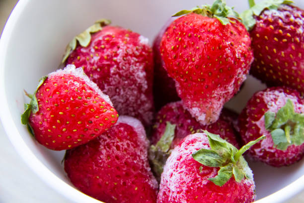 istock Frozen strawberries with ice on the plate. Frozen red berries. 1318409308