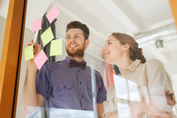istock creative team with stickers on glass at office 1318409734
