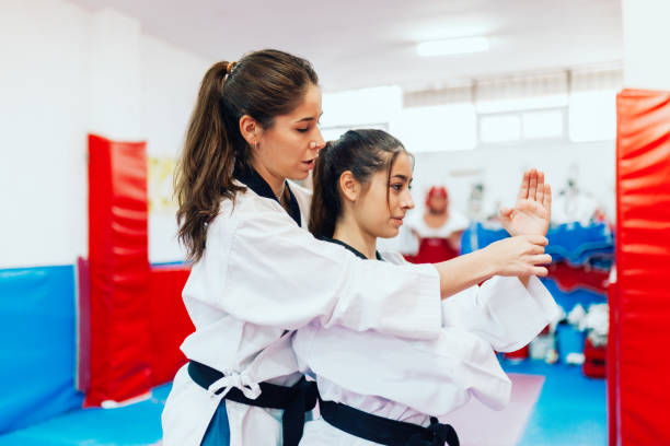 istock Two young women practice taekwondo in a training center 1318411721