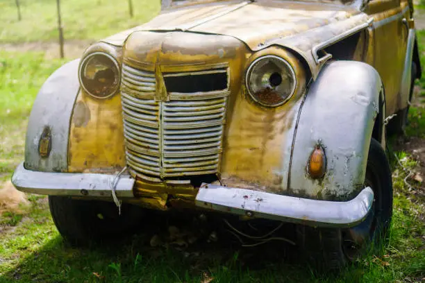 Photo of Vintage rusty passenger car in the park.