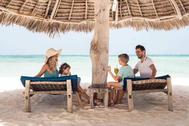 istock Happy family talking under sunshade on the beach. 1318413435