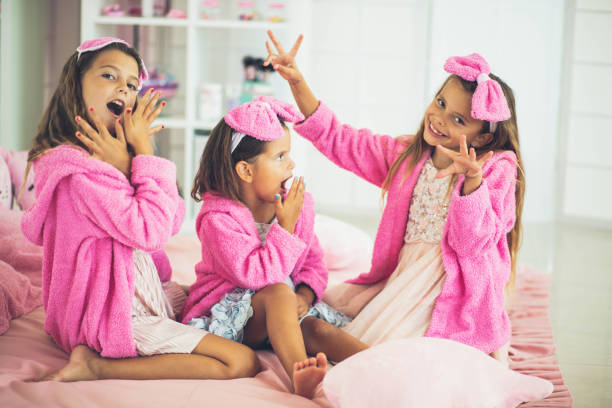 three little girl sitting on bed. little girl showing her nails. - child party group of people little girls imagens e fotografias de stock