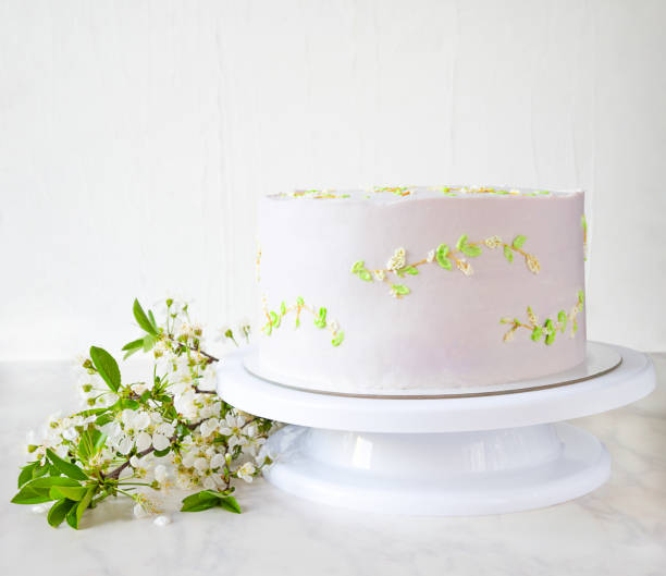 istock Wedding pink cake on a stand with branches of cherry blossoms. delicate decor on cake 1318415192