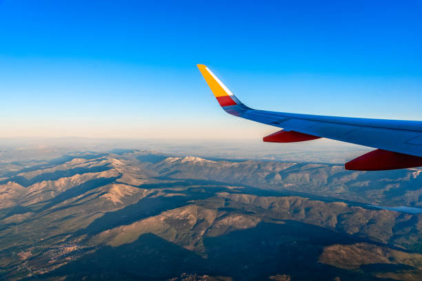 山脈の上空を飛ぶ飛行機の翼。グアダラマ、ナバセラダ。旅行コンセプト - mountain range earth sky airplane ストックフォトと画像
