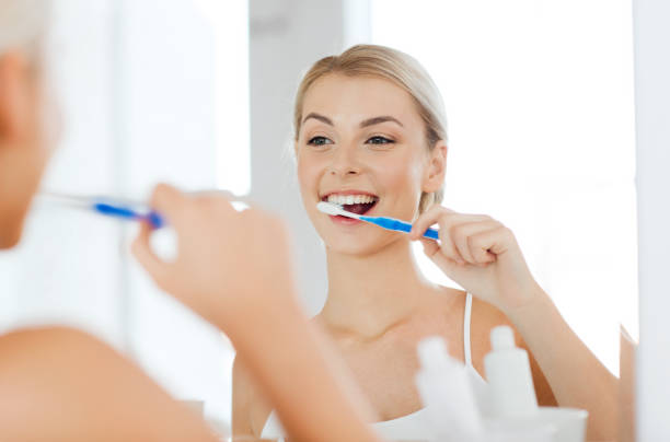 istock woman with toothbrush cleaning teeth at bathroom 1318417984