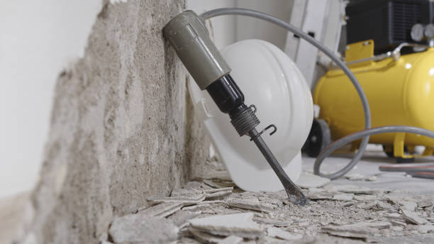 house renovation concept, wall in demolition with plaster rubble and protective construction work tools, helmet, yellow compressor and pneumatic air hammer chisel, close up on floor house renovation concept, wall in demolition with plaster rubble and protective construction work tools, helmet, yellow compressor and pneumatic air hammer chisel, close up on floor dismantling photos stock pictures, royalty-free photos & images