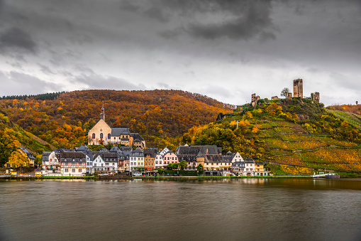 Idylic german village at the river mosel surrounded by colourful forest at autumn time. Rhineland Palatinate in Germany.