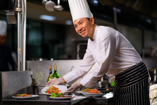 istock Asian Male chef presenting the dish in the kitchen. Selective focus. 1318422421